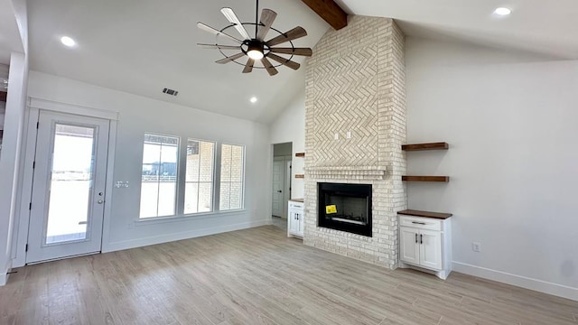 2118 S County Rd 1059, Midland, TX 79706 - unfurnished living room with a ceiling fan, beamed ceiling, a fireplace, light wood-style floors, and baseboards