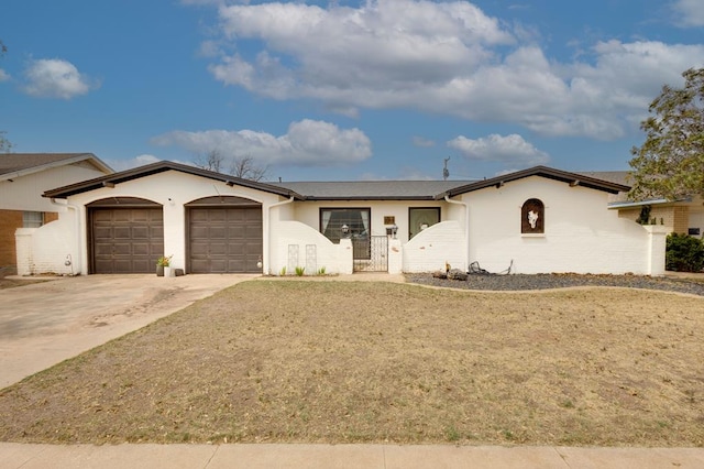 single story home featuring a gate, driveway, stucco siding, and an attached garage