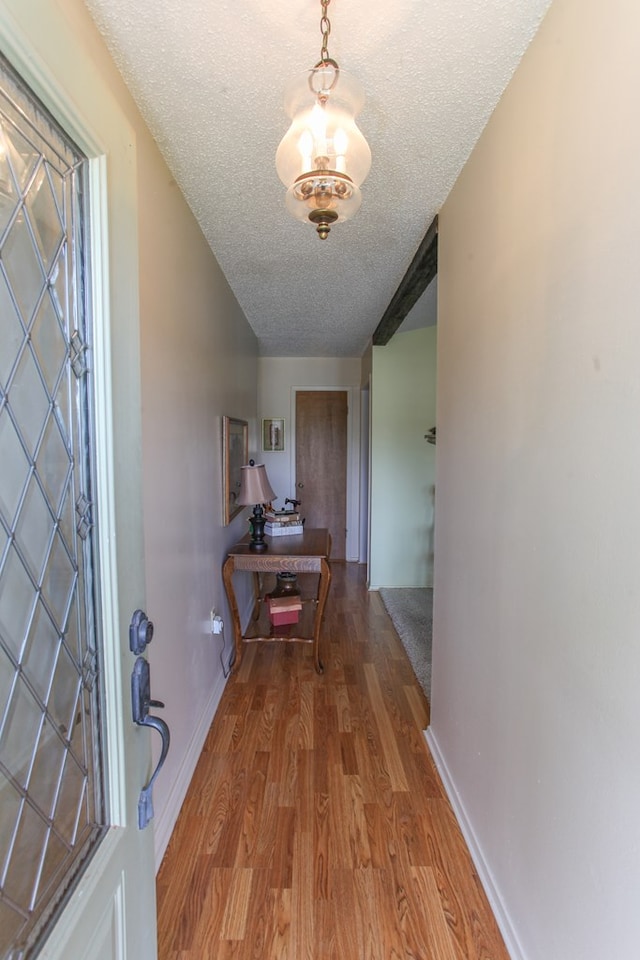 702 Capri Ct, Big Spring, TX 79720 - corridor with a textured ceiling and wood finished floors