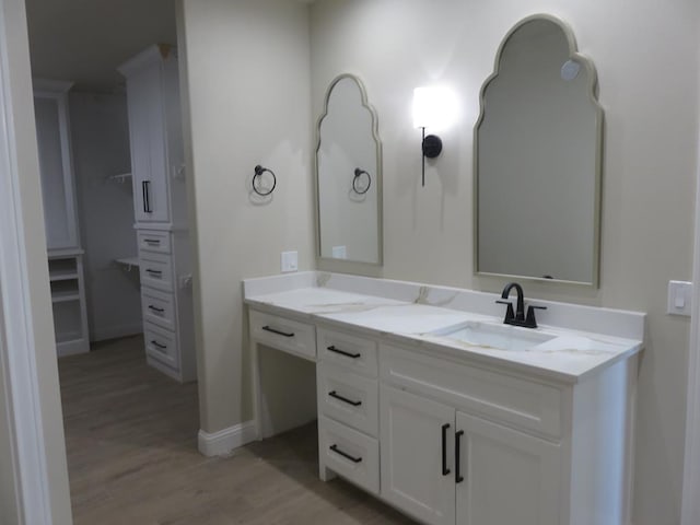 bathroom with baseboards, vanity, and wood finished floors