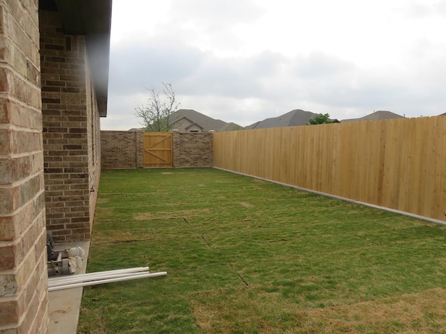 view of yard with a gate and a fenced backyard