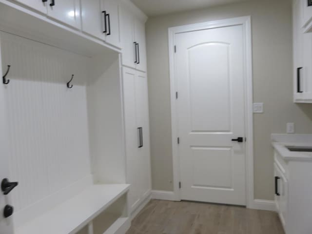 mudroom featuring baseboards and light wood-style floors