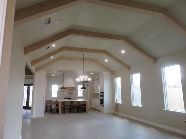 unfurnished living room with lofted ceiling with beams, recessed lighting, a chandelier, light wood finished floors, and baseboards