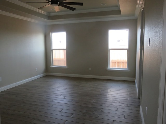 empty room with a raised ceiling, ornamental molding, and ceiling fan