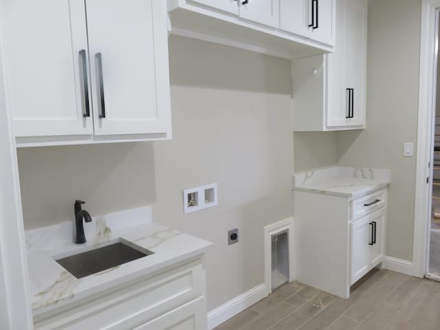 clothes washing area with light wood-style flooring, a sink, cabinet space, washer hookup, and hookup for an electric dryer