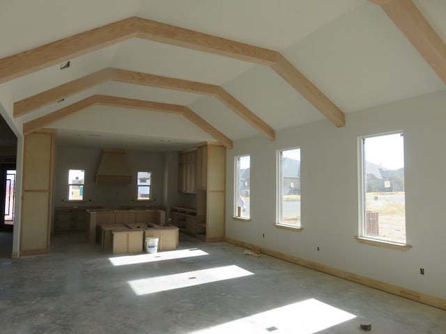 unfurnished living room featuring concrete floors and vaulted ceiling