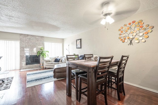 4700 Boulder Dr Unit 1604, Midland, TX 79707 - dining space featuring a textured ceiling, hardwood / wood-style flooring, ceiling fan, a fireplace, and baseboards