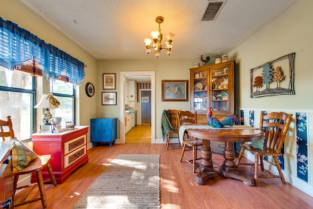 707 E County Rd 132, Midland, TX 79706 - dining space featuring a chandelier, a textured ceiling, light wood-style floors, and baseboards