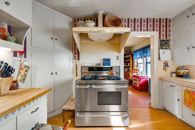 707 E County Rd 132, Midland, TX 79706 - kitchen featuring range with two ovens, a textured ceiling, light wood-type flooring, wallpapered walls, and white cabinets