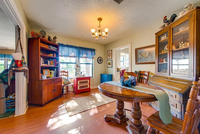 707 E County Rd 132, Midland, TX 79706 - dining area featuring a chandelier, wood finished floors, and a textured ceiling