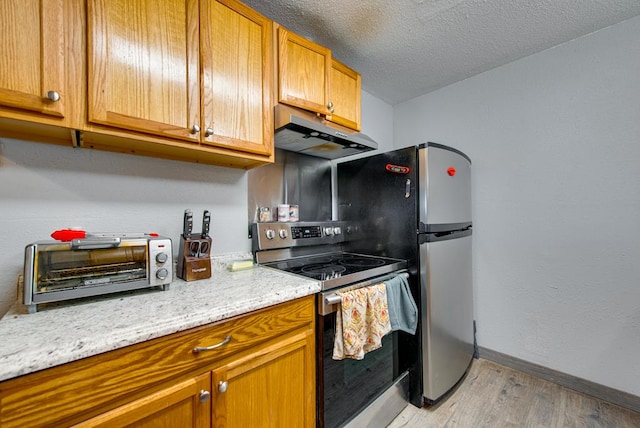 707 E County Rd 132, Midland, TX 79706 - kitchen featuring stainless steel electric stove, under cabinet range hood, light wood finished floors, baseboards, and a textured ceiling