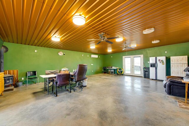 707 E County Rd 132, Midland, TX 79706 - dining room featuring finished concrete floors, a wood stove, a ceiling fan, and french doors