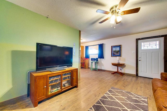 707 E County Rd 132, Midland, TX 79706 - living room featuring a ceiling fan, baseboards, healthy amount of natural light, light wood finished floors, and a textured ceiling
