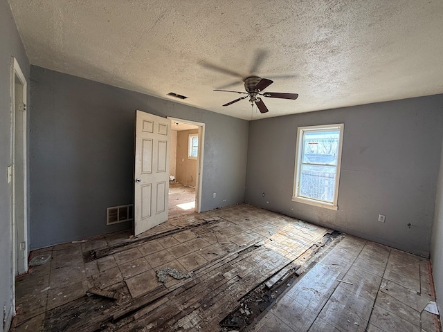 unfurnished room featuring ceiling fan, a textured ceiling, and visible vents