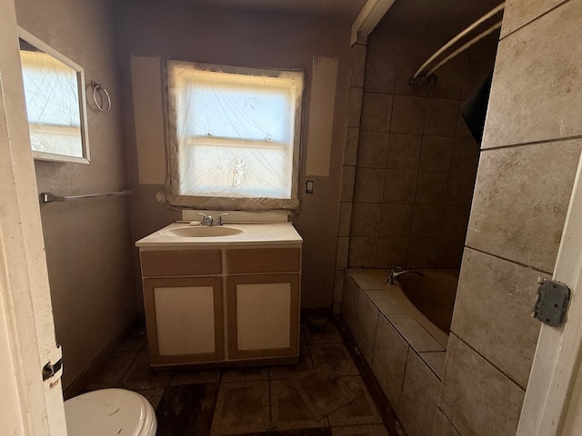 full bathroom with tiled shower / bath combo, vanity, and toilet