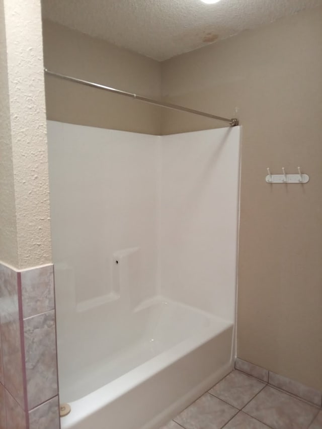 1607 E Pecan Ave, Midland, TX 79705 - bathroom with a textured ceiling, tile patterned flooring, and shower / bathtub combination