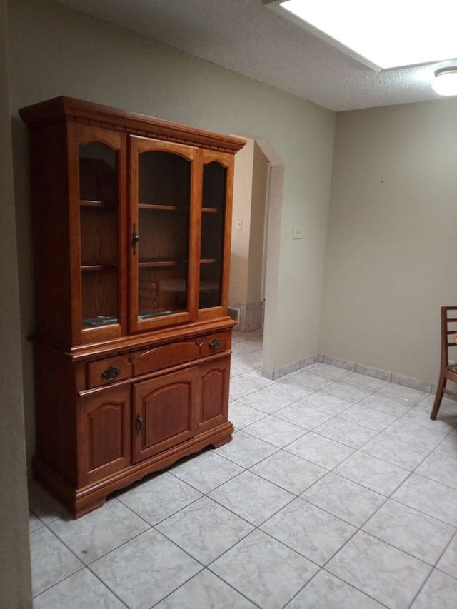 1607 E Pecan Ave, Midland, TX 79705 - unfurnished dining area with arched walkways and light tile patterned flooring