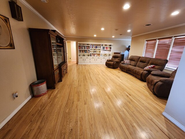 living room with light wood-type flooring and ornamental molding