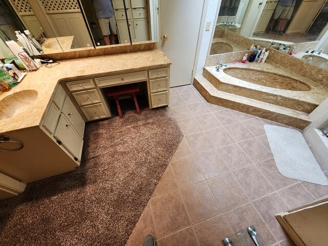 bathroom with tile patterned flooring, vanity, and a tub