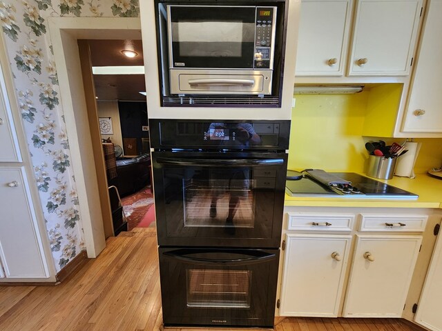 kitchen with black oven and white cabinetry