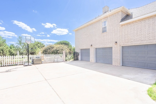 209 Bayberry Pkwy, Midland, TX 79705 - view of home's exterior featuring brick siding, a garage, concrete driveway, and a chimney