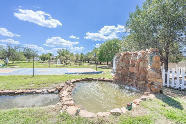 209 Bayberry Pkwy, Midland, TX 79705 - view of yard with community basketball court and a garden pond