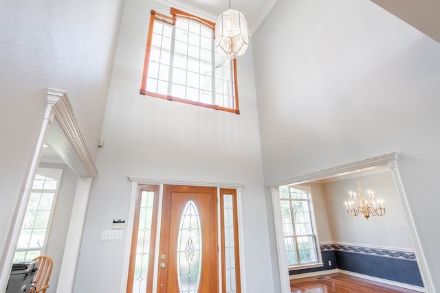 209 Bayberry Pkwy, Midland, TX 79705 - entrance foyer featuring a high ceiling, a chandelier, wood finished floors, baseboards, and ornamental molding