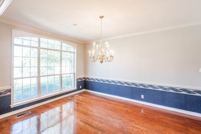 209 Bayberry Pkwy, Midland, TX 79705 - unfurnished room featuring crown molding, a chandelier, wood finished floors, baseboards, and wainscoting