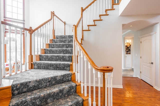 209 Bayberry Pkwy, Midland, TX 79705 - stairway with plenty of natural light, arched walkways, wood finished floors, baseboards, and a high ceiling