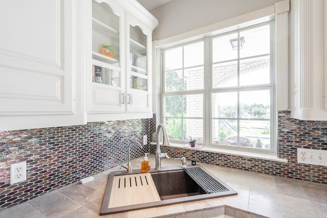 209 Bayberry Pkwy, Midland, TX 79705 - kitchen featuring a sink, decorative backsplash, white cabinetry, glass insert cabinets, and stone finish flooring
