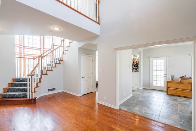 209 Bayberry Pkwy, Midland, TX 79705 - foyer entrance with stairs, a towering ceiling, baseboards, and arched walkways