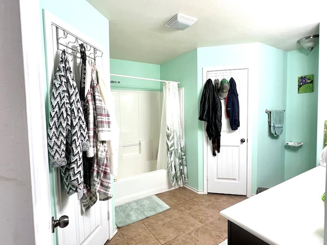 bathroom featuring tile patterned flooring, shower / bath combo, and vanity