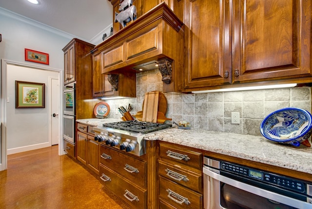 kitchen with appliances with stainless steel finishes, ornamental molding, decorative backsplash, light stone countertops, and baseboards
