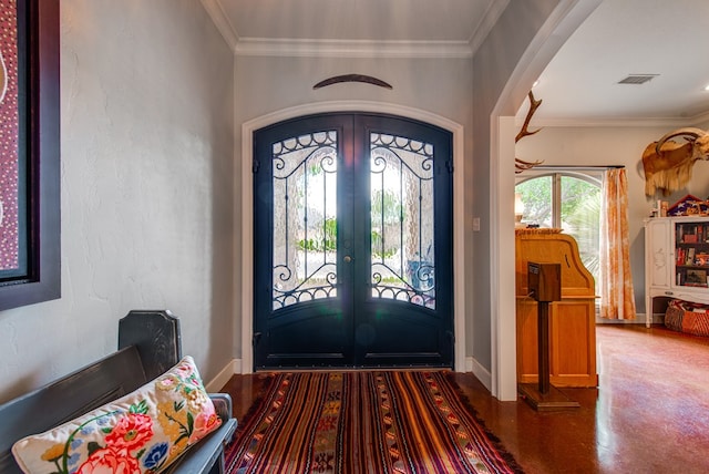 entryway with arched walkways, french doors, and crown molding