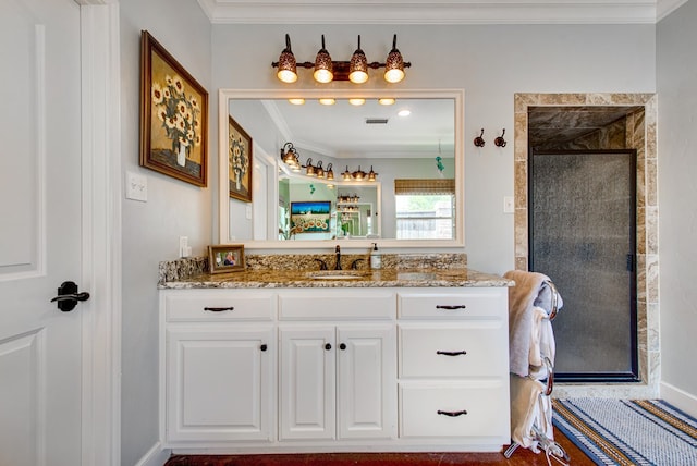 full bath featuring ornamental molding, tiled shower, and vanity