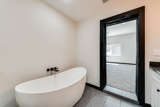 bathroom featuring vanity and a freestanding bath
