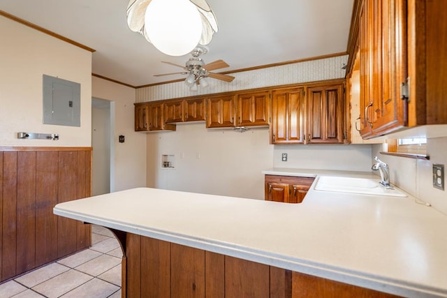 kitchen with sink, kitchen peninsula, ornamental molding, ceiling fan, and electric panel