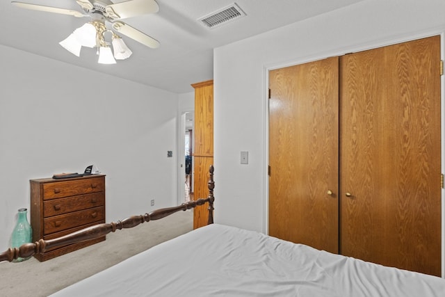 carpeted bedroom with ceiling fan and a closet