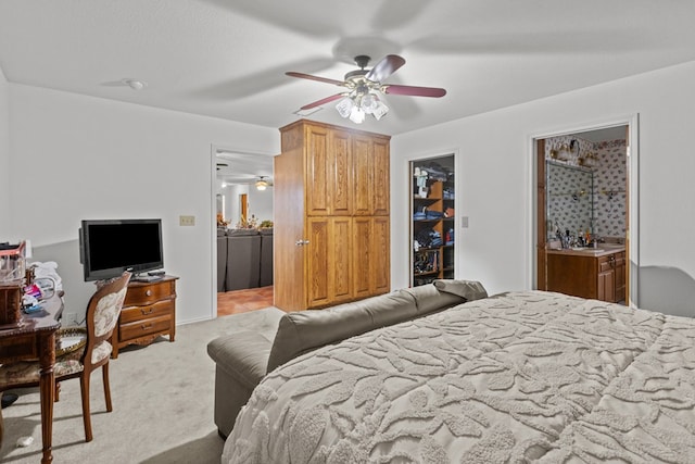 bedroom with ceiling fan, a spacious closet, ensuite bathroom, light carpet, and a closet