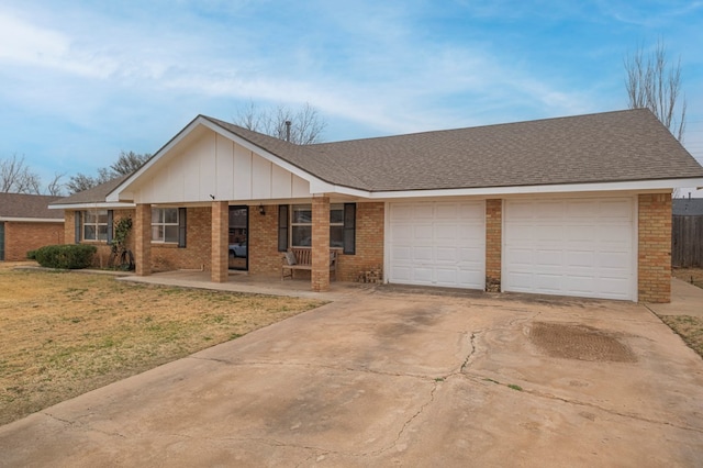 ranch-style house featuring a garage, covered porch, and a front yard