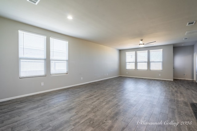 empty room with ceiling fan and dark hardwood / wood-style flooring