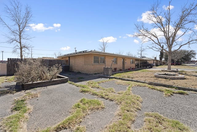 exterior space with brick siding, central AC, and fence