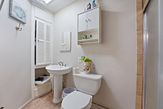 full bath featuring toilet, a shower with door, and a sink