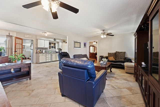 living area featuring a textured ceiling and ceiling fan