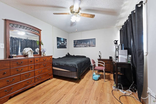 bedroom featuring light wood finished floors, a textured ceiling, and a ceiling fan