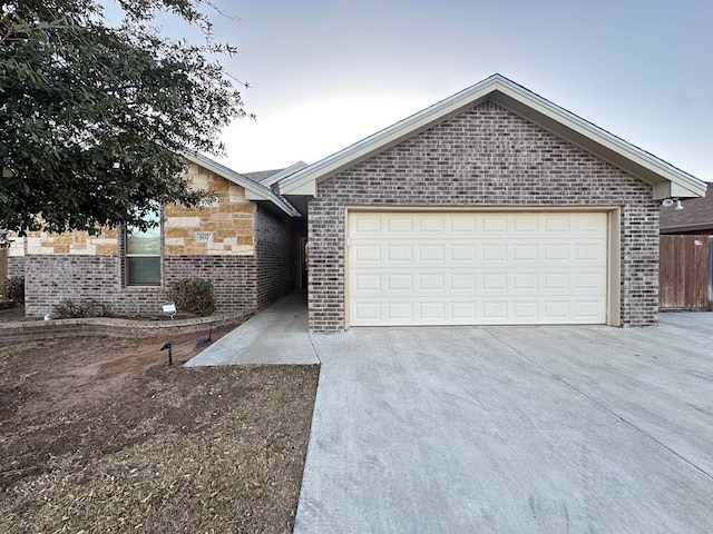 ranch-style home with a garage, concrete driveway, brick siding, and stone siding