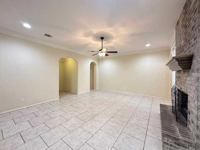 unfurnished living room featuring light tile patterned floors, arched walkways, a ceiling fan, ornamental molding, and a fireplace