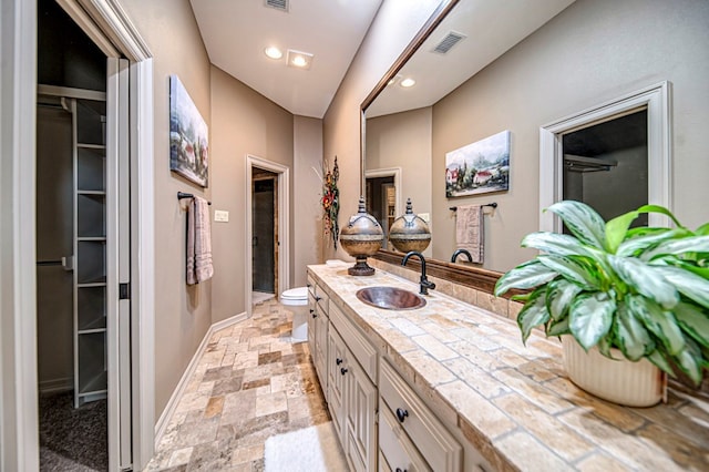 full bath with visible vents, baseboards, stone finish flooring, vanity, and recessed lighting