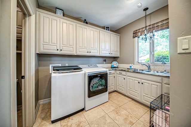 laundry area with cabinet space, washing machine and dryer, a sink, and light tile patterned flooring