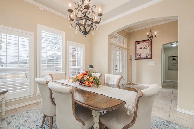 dining room with crown molding, light tile patterned floors, a chandelier, and a tray ceiling